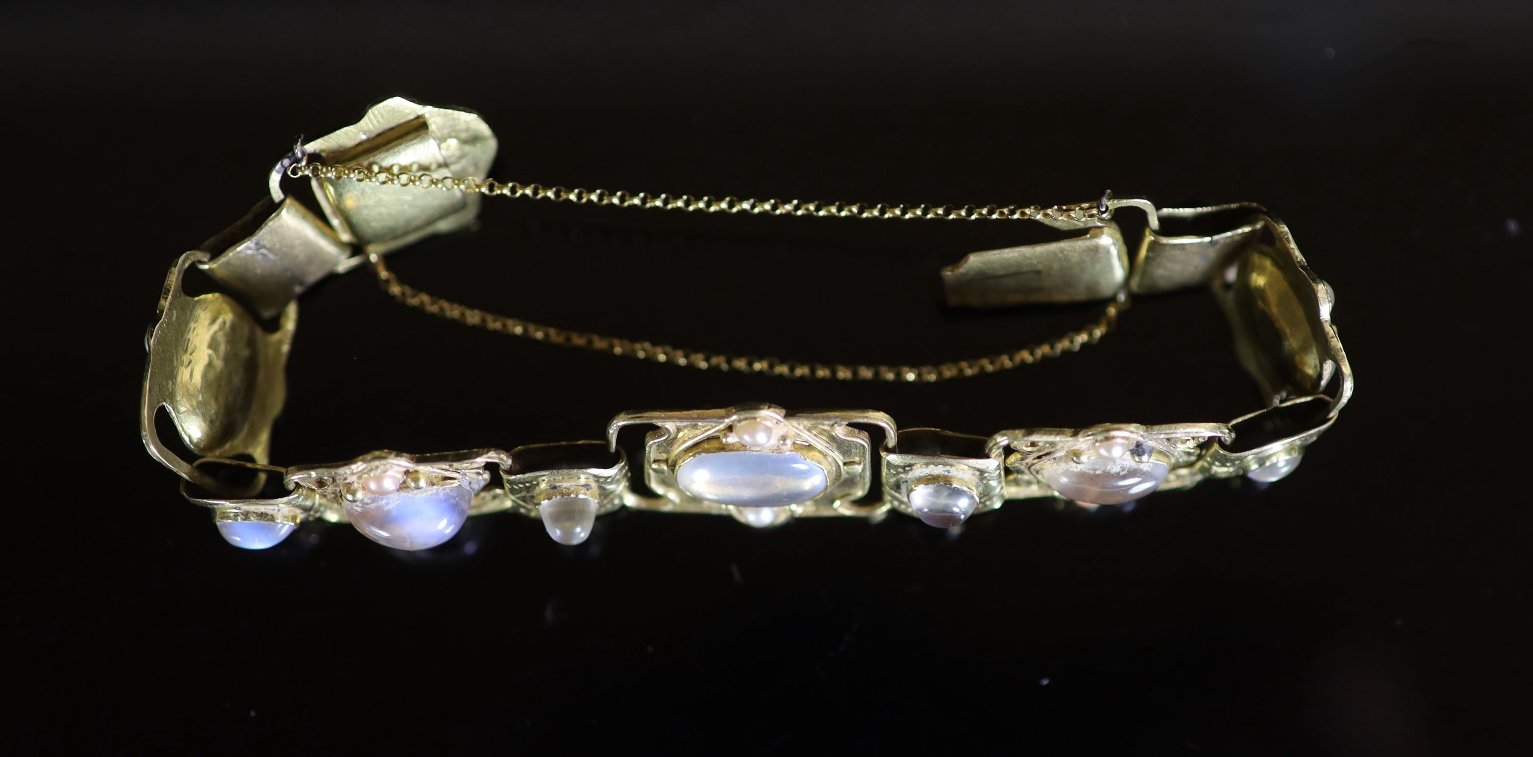 An early 20th century Arts & Crafts gold, cabochon moonstone and split pearl set bracelet